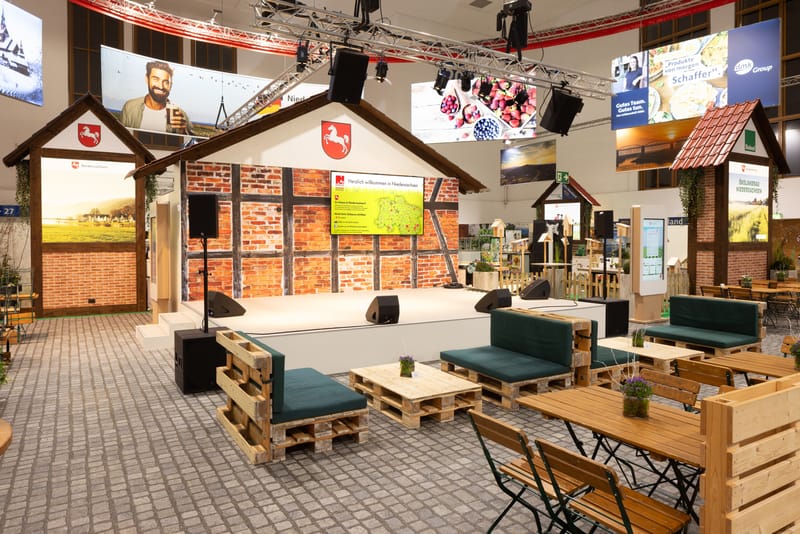 Showbühne der Niedersachsenhalle mit Fachwerk-Kulisse, Niedersachsen-Wappen und Lounge-Bestuhlung davor