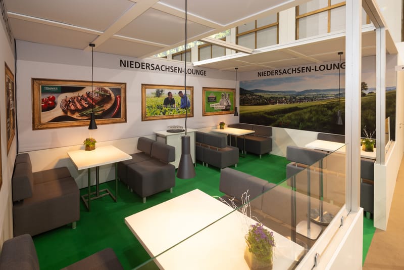 Blick in die Niedersachsen-Lounge in Halle 20 mit Sitzbereich, Beschriftung und Partnermotiven