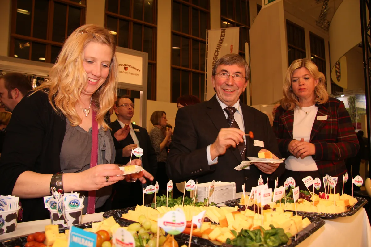 Niedersachsenabend 2012: Gastgeber und Besucherin probieren am Buffet niedersächsische Produkte