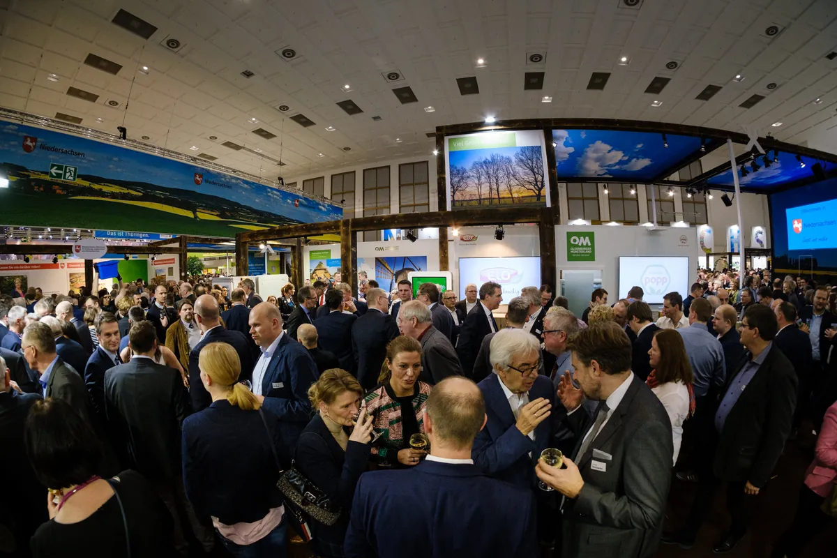 Niedersachsenabend 2020: prall gefüllte Halle mit Landschaftspanorama und Aussteller-Screens